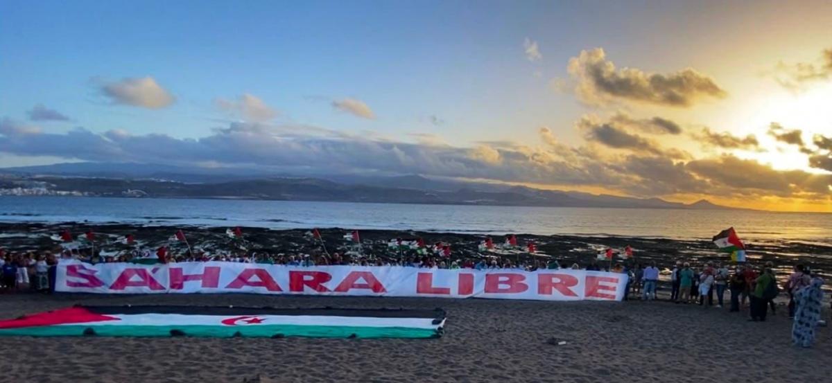Pancarta gigante desplegada por el movimiento de solidaridad, en la Playa del Confital, el 26 de agosto de 2022 (foto de Facebook)